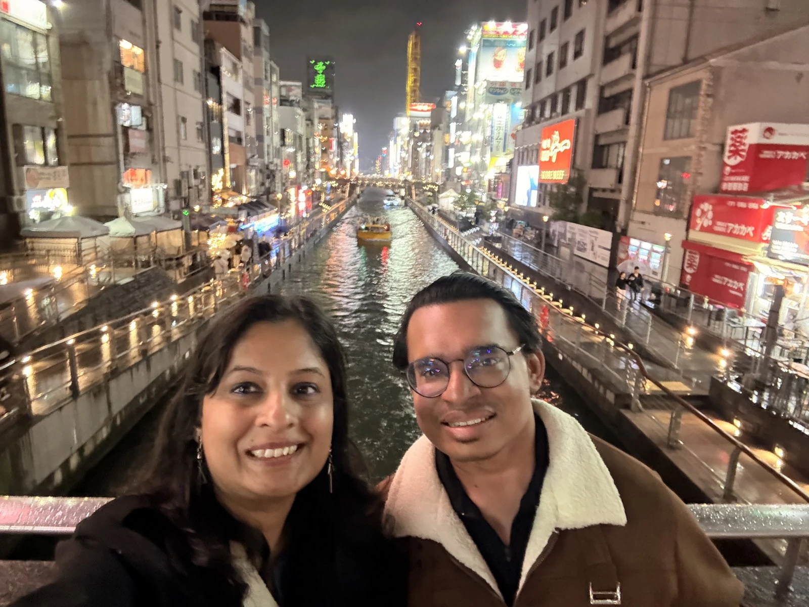 Looking out over the Dotonbori canal at night, neon reflecting on the water