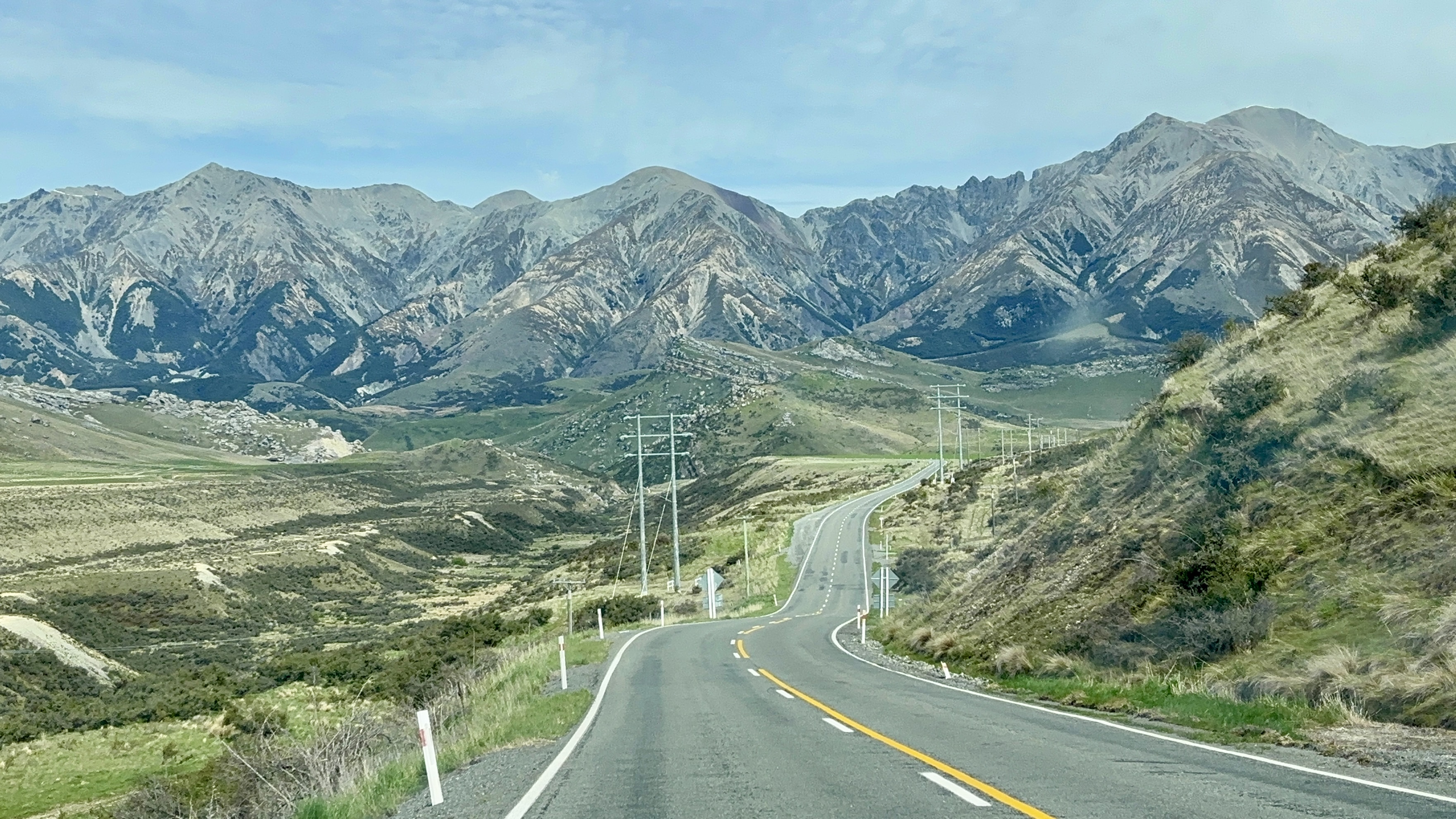 Panoramic view of mountain ranges, wide yellow valley fields, and clear blue sky