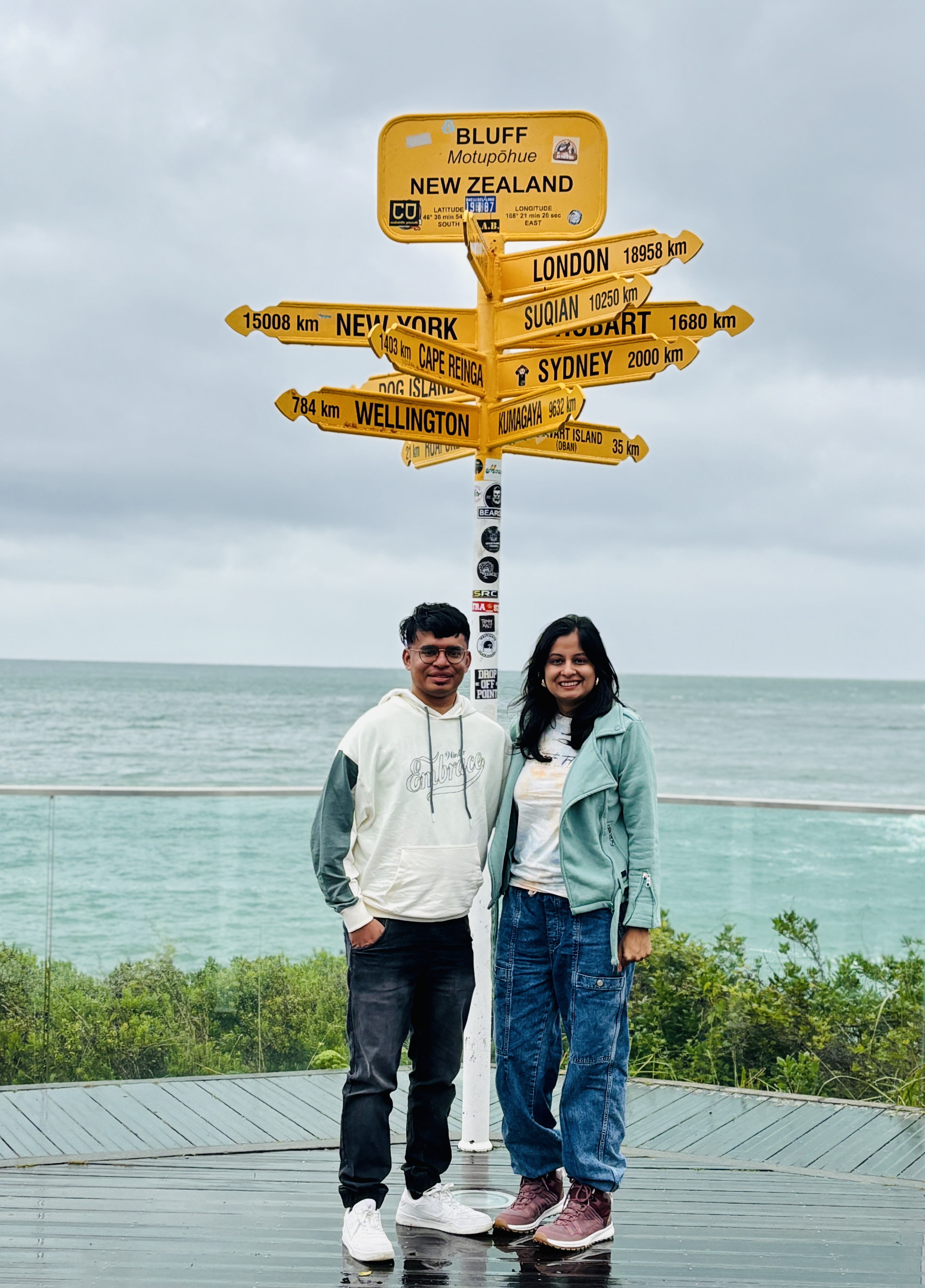 Iconic yellow signposts at Stirling Point in Bluff under rainy skies