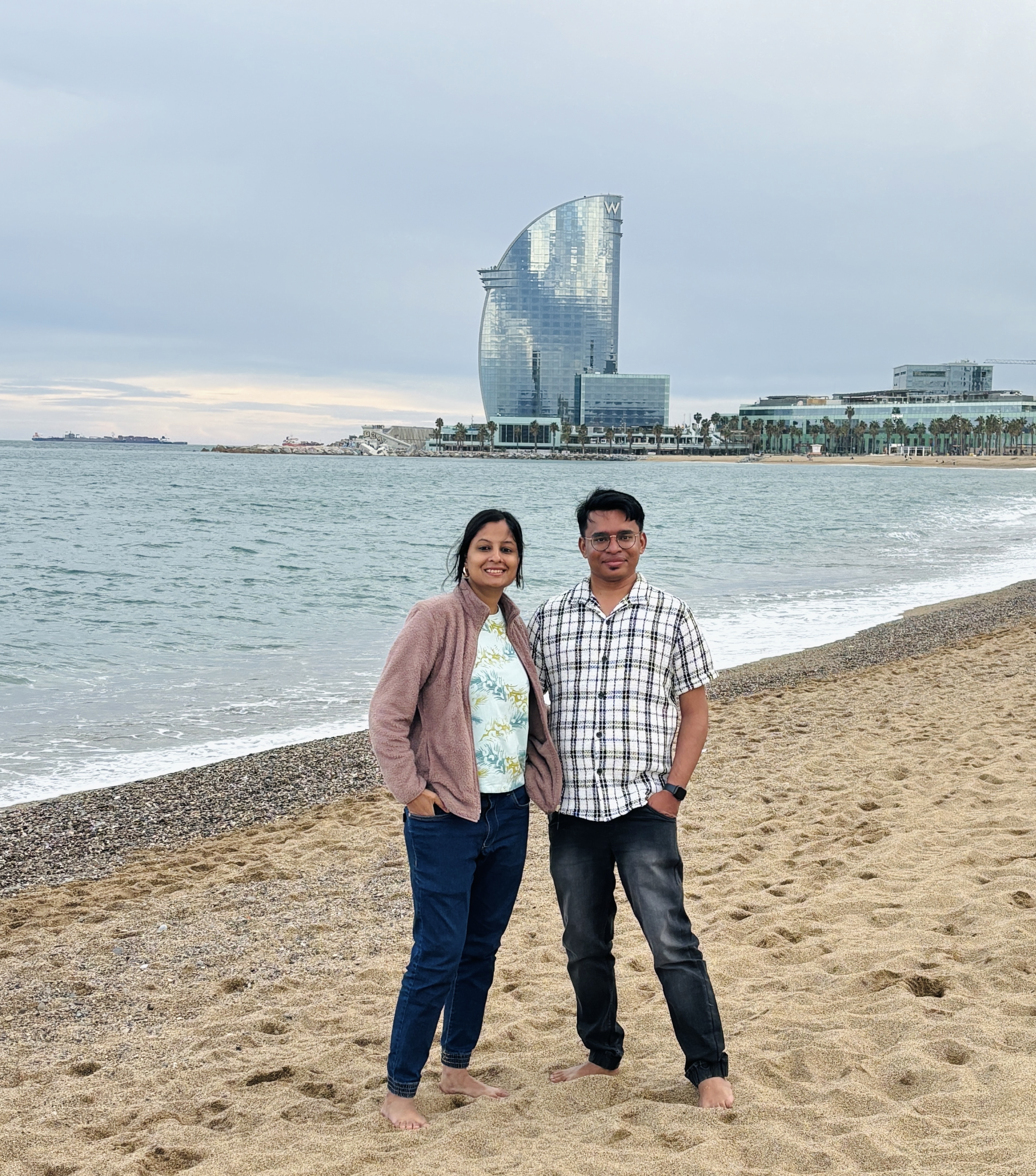 A couple relaxing on Barceloneta Beach at golden hour