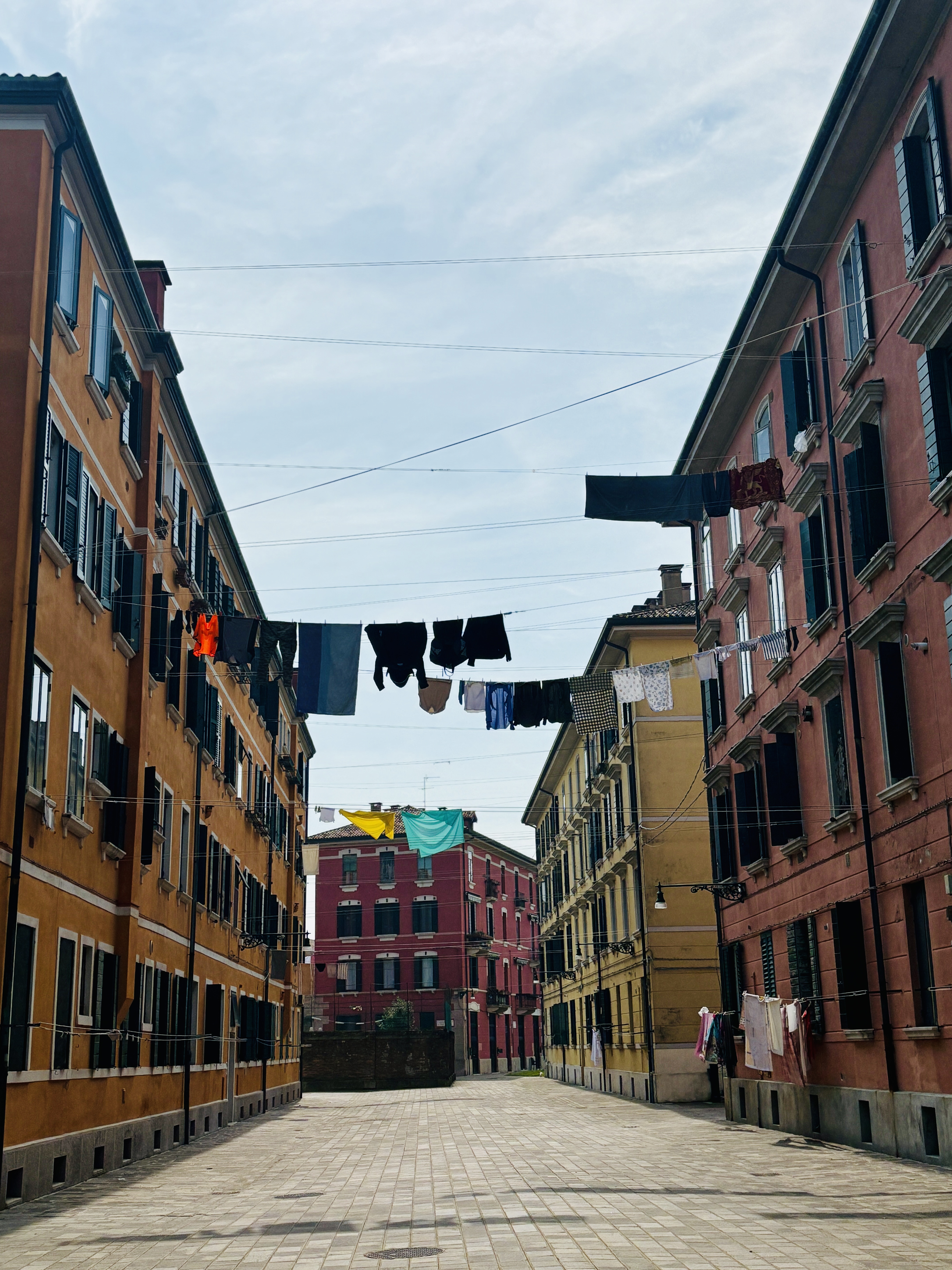 Laundry hanging on clotheslines between Venetian buildings over the alleyway