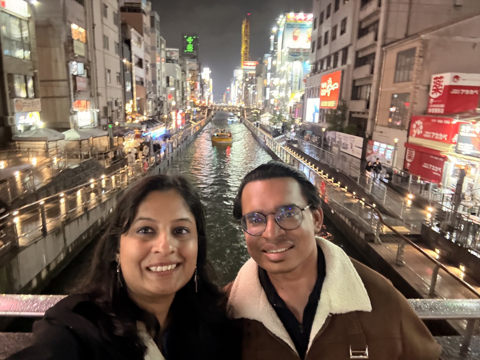 Looking out over the Dotonbori canal at night, neon reflecting on the water